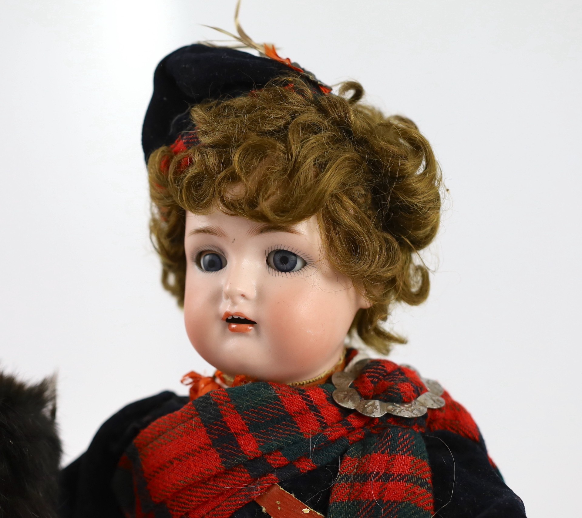 An Armand Marseille bisque Scottish soldier doll, German, circa 1900, 15in. (2)